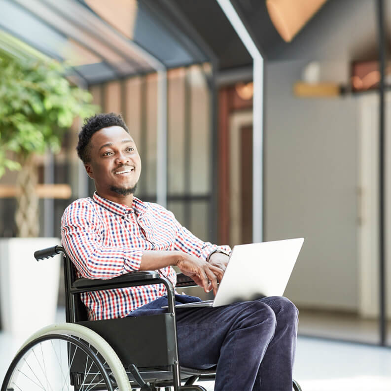 Mann, der draußen am Laptop arbeitet