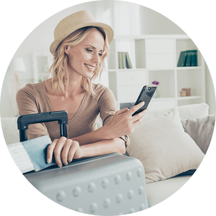 Woman with suitcase smiling at phone